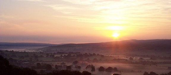 Picture of sun rising over villages in Pendle - (C) Andrew Stringer, 1999